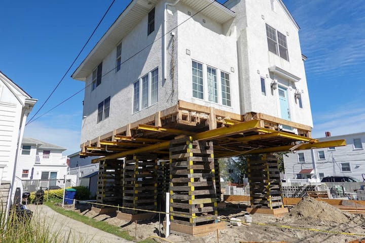 A team of professionals using specialized equipment to raise a house in Erie, preparing it for elevation and renovation